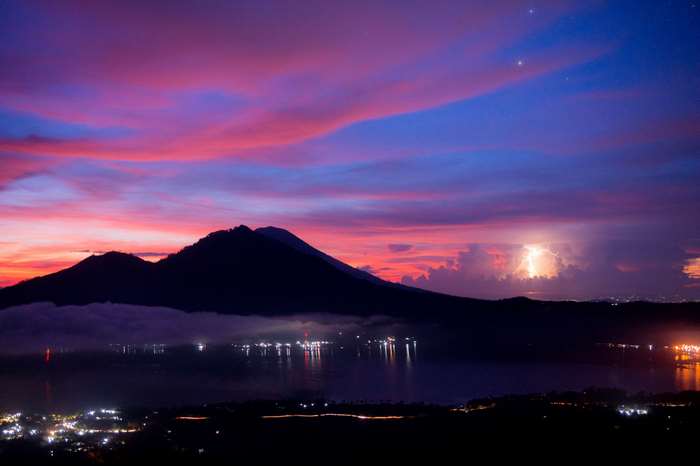 Mountains and lake at sunset with lightning