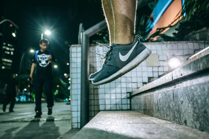 Man jumping on steps at night with Nike shoes