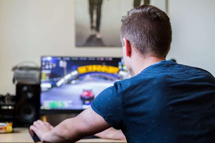 Man playing Trackmania 4K on a computer