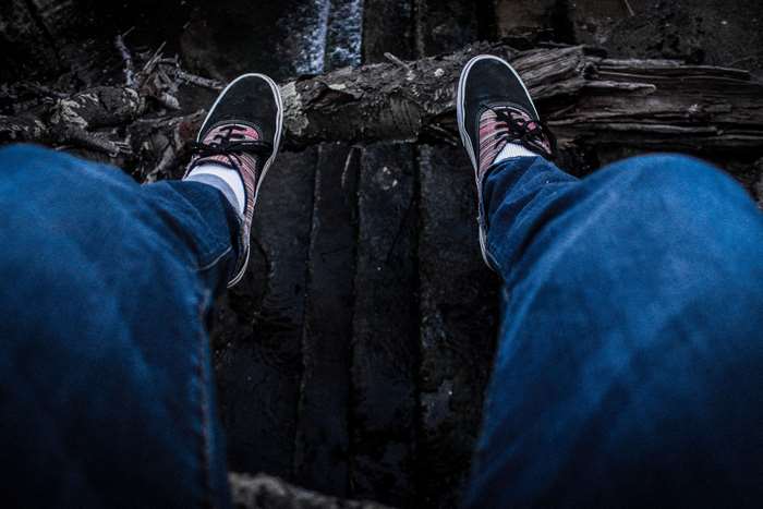 Person wearing Vans sneakers and blue jeans