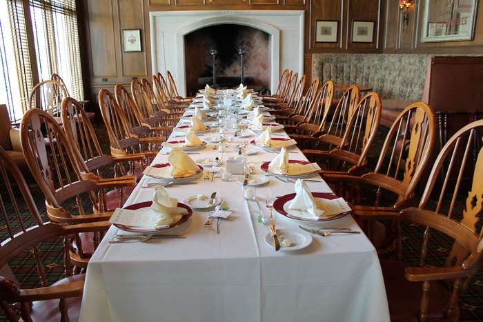 Formal dining room with a long table set for a meal