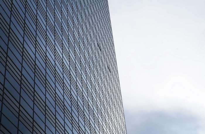 Modern glass skyscraper against a cloudy sky