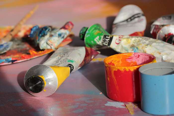 Art supplies: paint tubes, palette, and cups