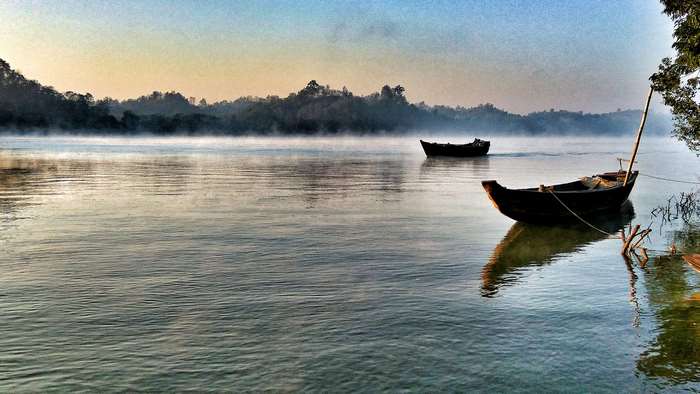 Boats on a foggy river at sunrise