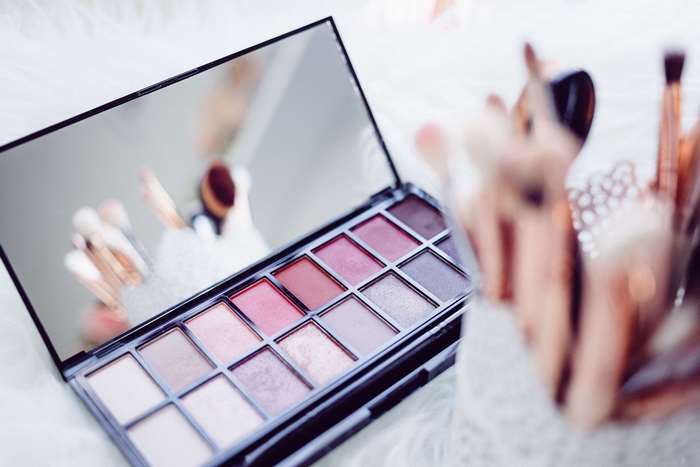 Makeup palette and brushes on a fluffy surface