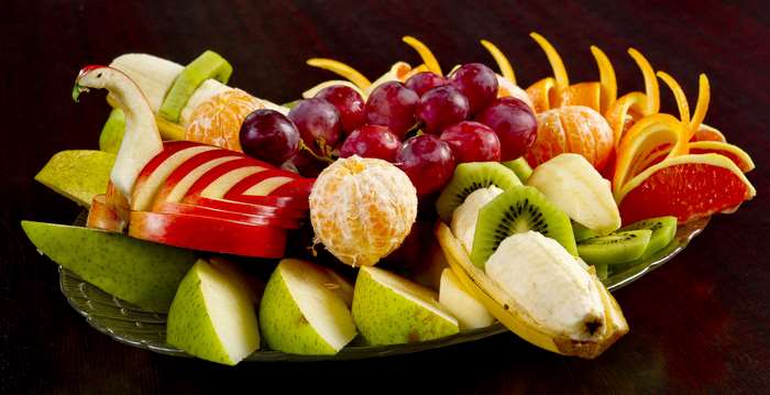 Fruit platter with carved apple swan, grapes, oranges, kiwi, and grapefruit