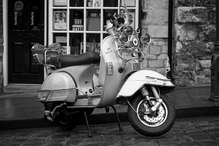 Vintage Vespa scooter parked on a cobblestone street