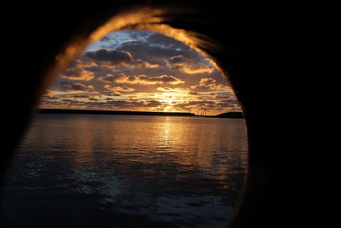 Sunset over the Baltic Sea with industrial structures