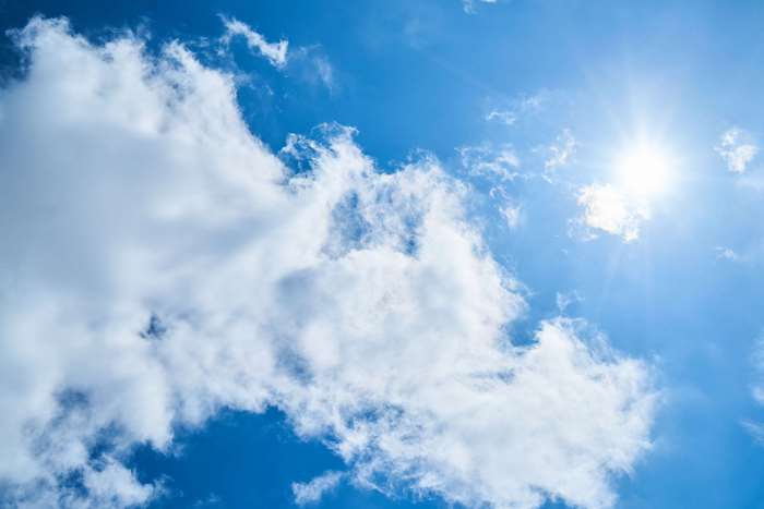 Blue sky with white clouds and sun