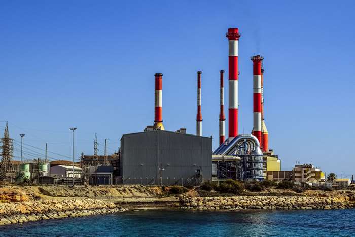 Industrial power plant with red and white smokestacks