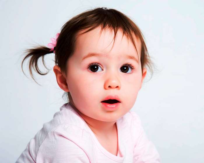 Close-up portrait of a baby girl with pigtails