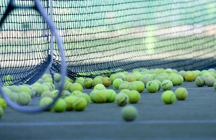 Tennis balls on a court near a net