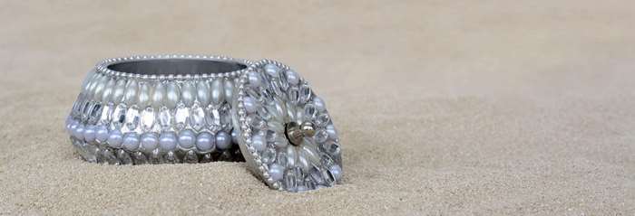 Ornate Silver Jewelry Box with Pearls and Gems on Sand