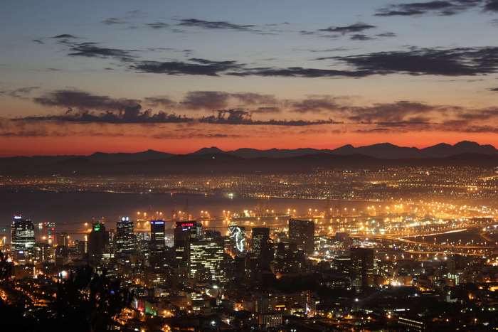 Cityscape at Dusk with Mountains and Water