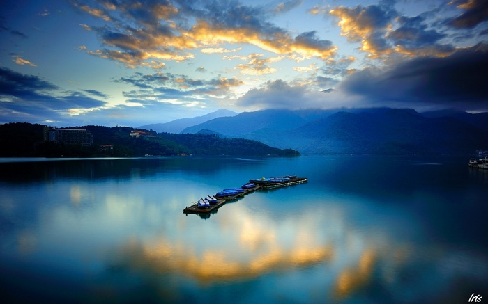 Floating docks with boats on a calm lake at sunrise