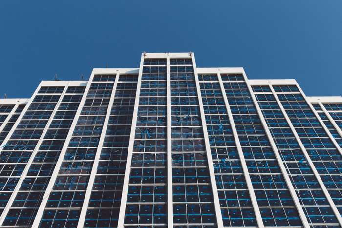 Modern building with glass windows against blue sky