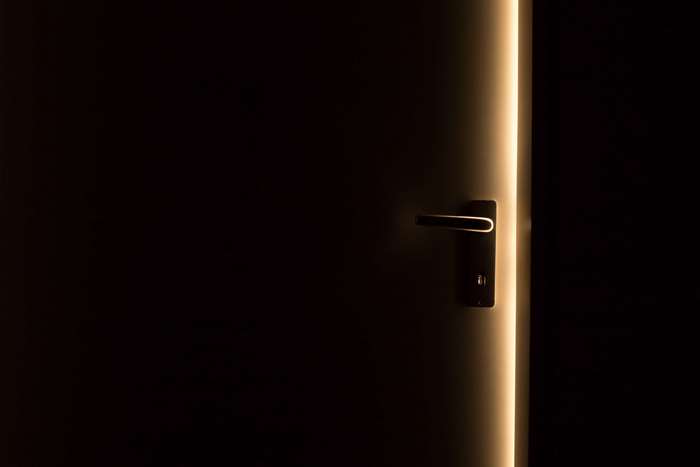 Dark door with illuminated edge and handle