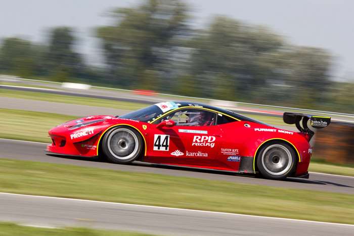 Red Ferrari racing car with number 44 on track