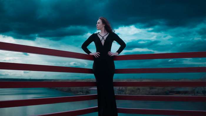 Woman in black dress on a bridge