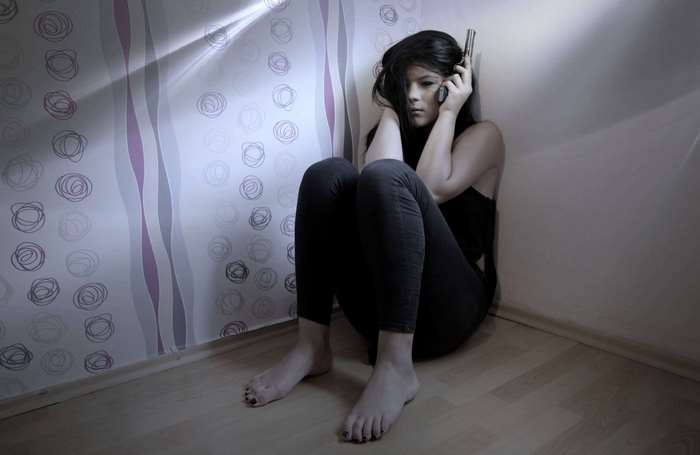 Woman holding a gun in a room