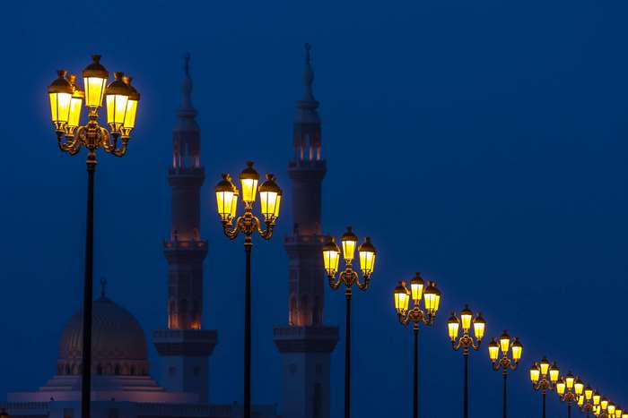 Mosque with ornate street lamps at dusk