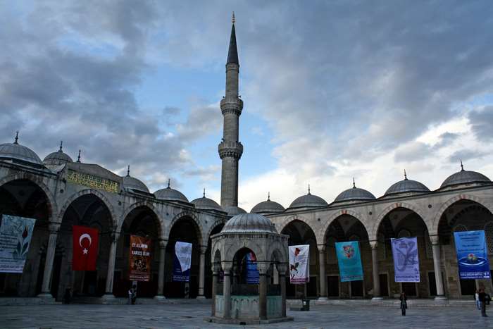 Blue Mosque courtyard with minaret and banners 4K