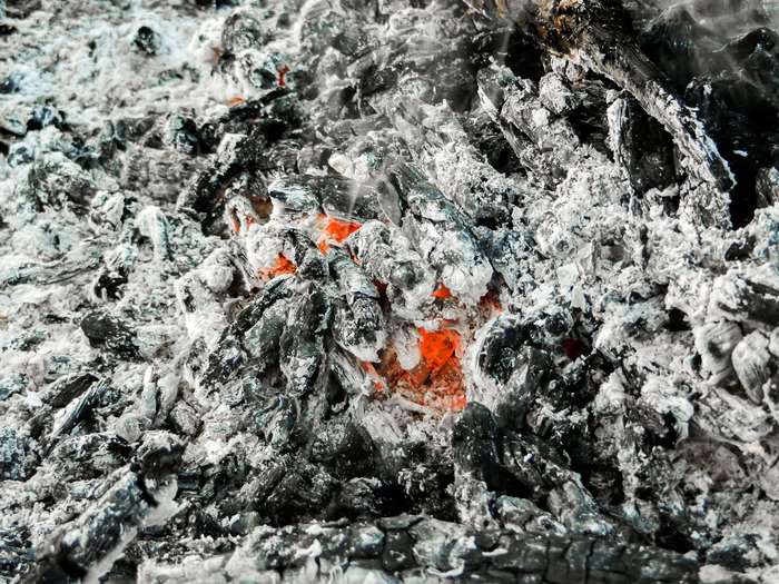 Close-up of glowing embers and ashes from a campfire