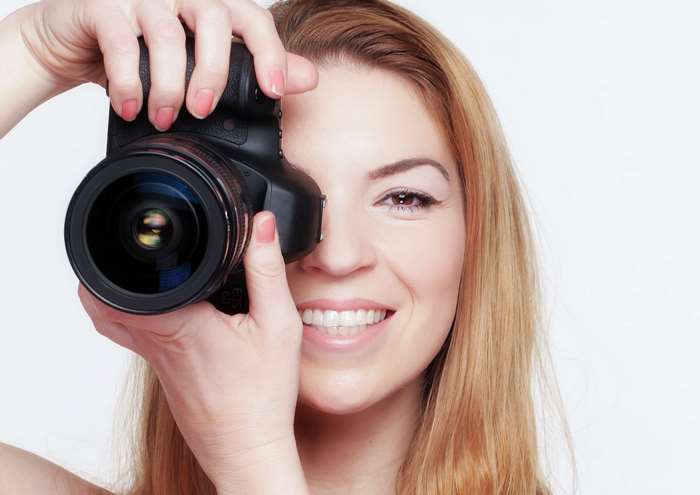 Woman holding a DSLR camera to take a photo