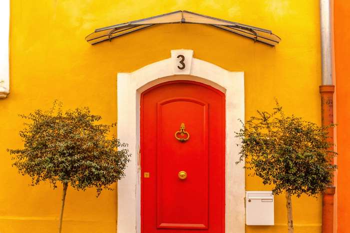 Red door with number 3 on yellow wall in France 4K