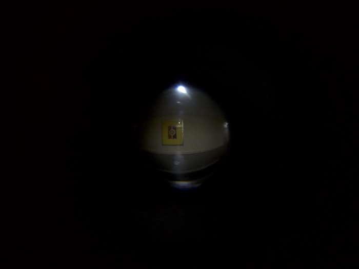 A yellow symbol on a round object in the dark