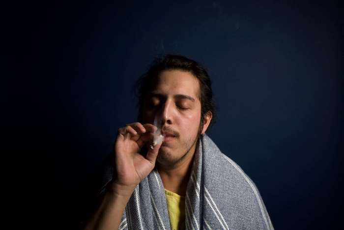 Man smoking a cigarette with smoke haze