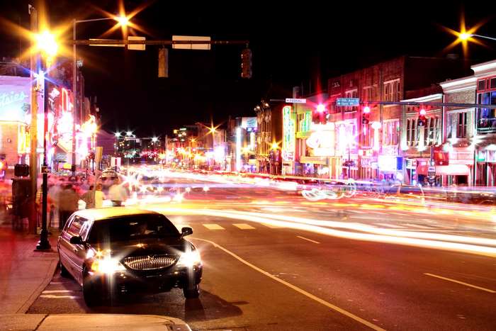 Broadway at night with light trails and a limousine