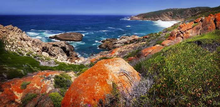 Cliff coast with blue water and red rocks, South Africa 4K