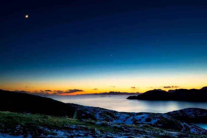 Moonlit Norwegian Fjord at Dusk with Snow-Capped Hills