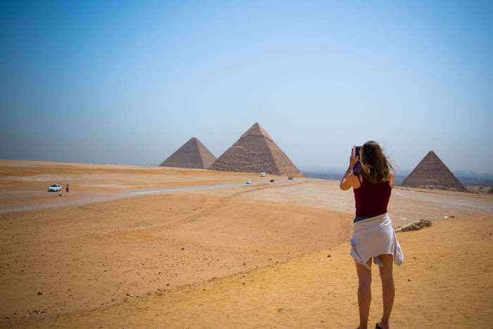 Woman photographing the Pyramids of Giza, Egypt