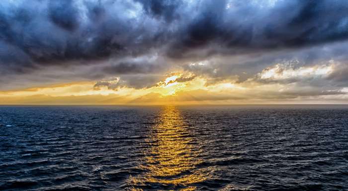 Sunset over the ocean with dramatic clouds