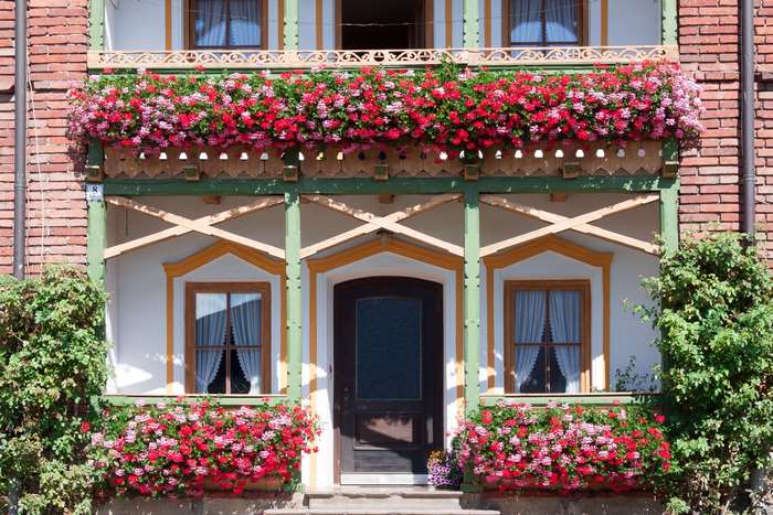 Rustic Bavarian farmhouse with flower-adorned balcony and windows
