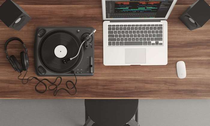 Turntable, laptop, headphones, speakers, and mouse on a desk