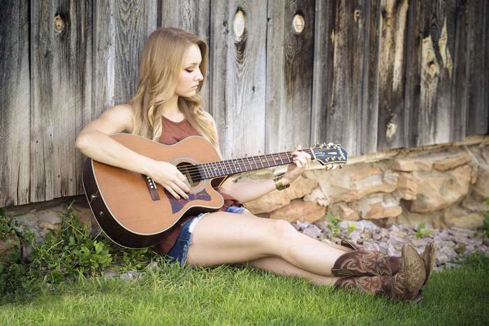 Woman playing acoustic guitar outdoors