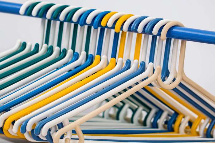Colorful plastic clothes hangers on a rack 4K