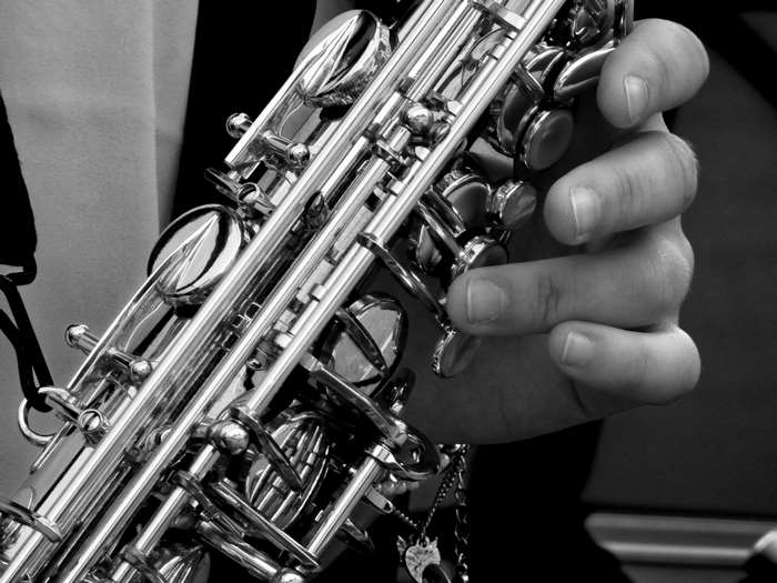 Black and white close-up of a hand playing a saxophone