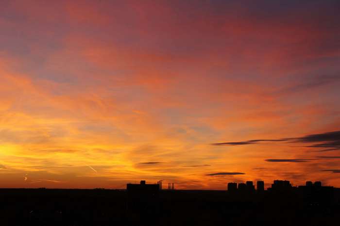 Cityscape at sunset with orange and yellow clouds