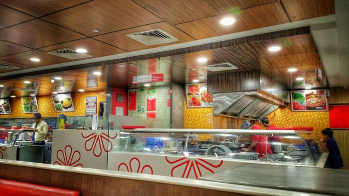 Fast food restaurant interior with food displays and staff