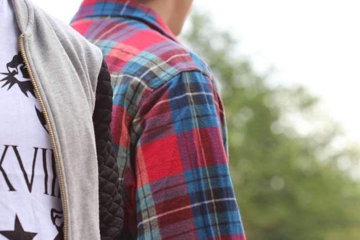 Two people wearing plaid and graphic t-shirts