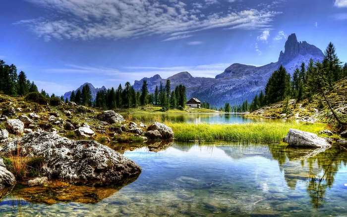 Mountain lake with a small house and trees
