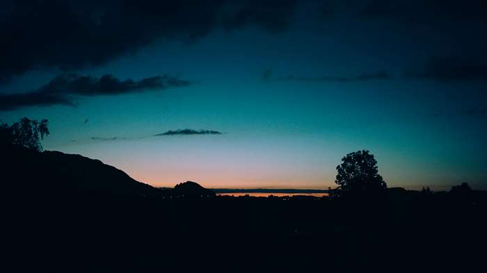Minimalist evening sky with silhouetted hills and trees