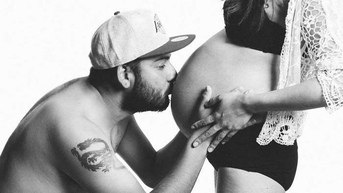 Man kissing pregnant woman's belly