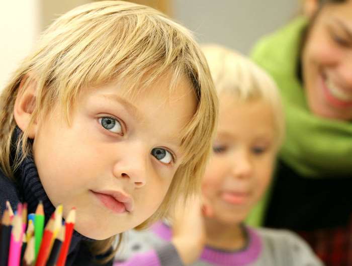 Children in a classroom with colored pencils