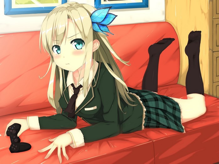 Girl with blonde hair playing video games on a sofa
