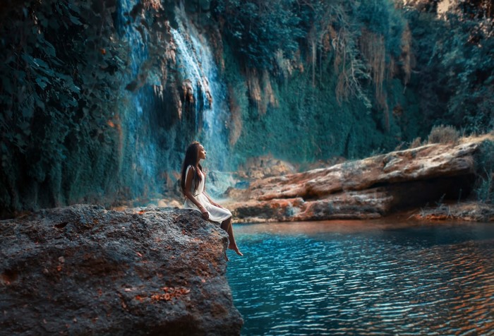 Girl Sitting on Rock Near Waterfall and River